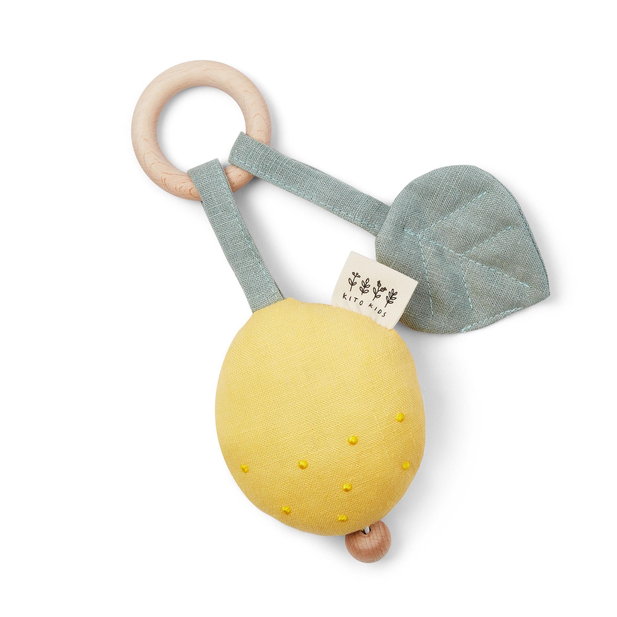 Boîte à musique pour bébé en forme de citron jaune en tissu avec une feuille verte et un anneau de dentition en bois sur fond blanc.