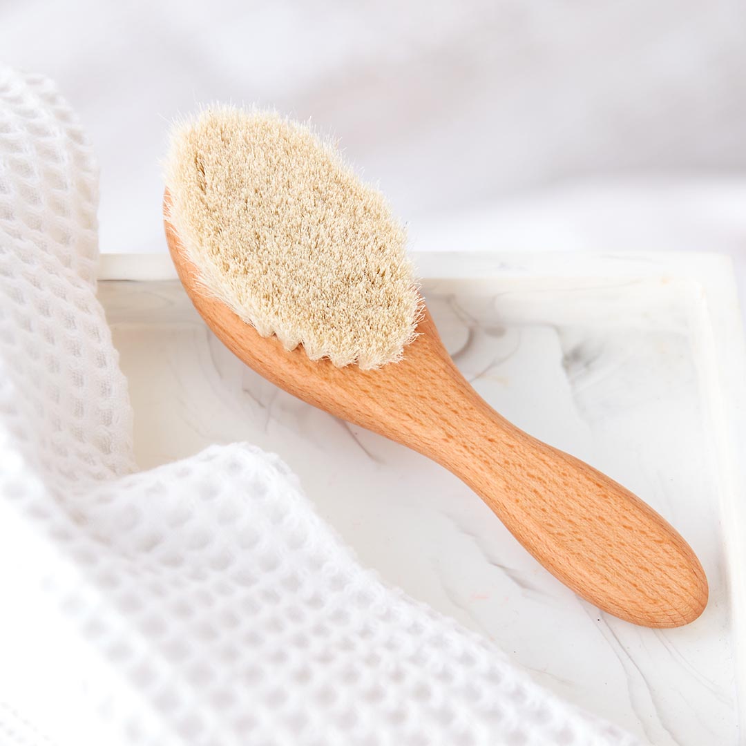 Brosse à cheveux pour bébé en bois de hêtre et poils de chèvre extra-doux pour coiffer en douceur et masser le cuir chevelu.