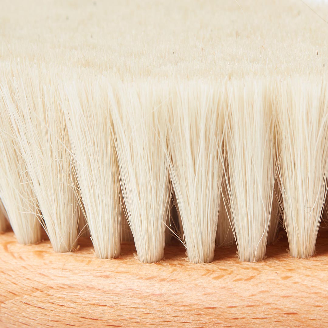Brosse pour bébé dotée de poils naturels ultra-doux d'une souplesse absolue, conçue pour masser délicatement le cuir chevelu sensible sans l'irriter.