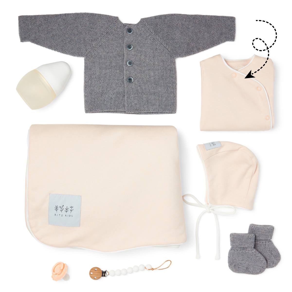 Coffret cadeau de naissance avec pyjama rose poudré, gilet en maille, couverture, bonnet, chaussons et accessoires pour nouveau-né.