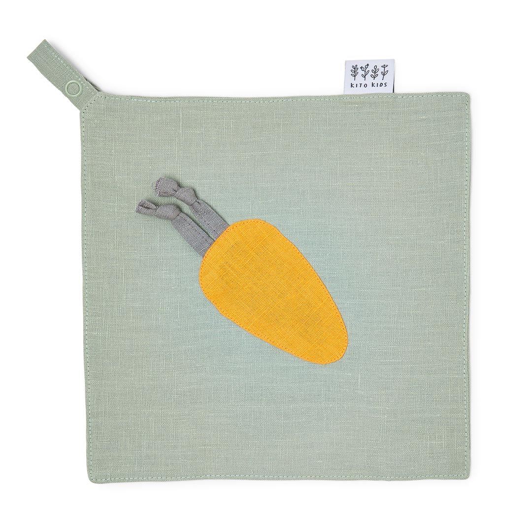Doudou plat carré en lin lavé vert sauge avec motif carotte jaune, muni d'une attache-tétine, présenté à plat sur fond blanc.