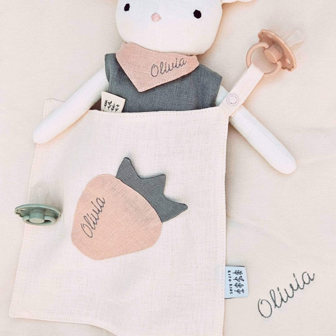 Un doudou souris en coton doux et une attache sucette assortie, parfait pour allier confort, hygiène et éveil sensoriel.