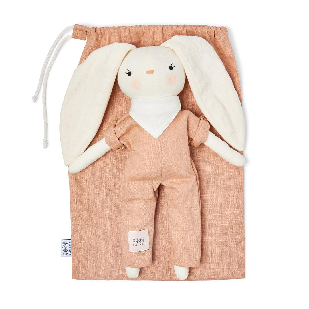 Coffret cadeau de naissance avec un doudou lapin en coton doux couleur pêche terracotta et son sac de rangement à cordon blanc.