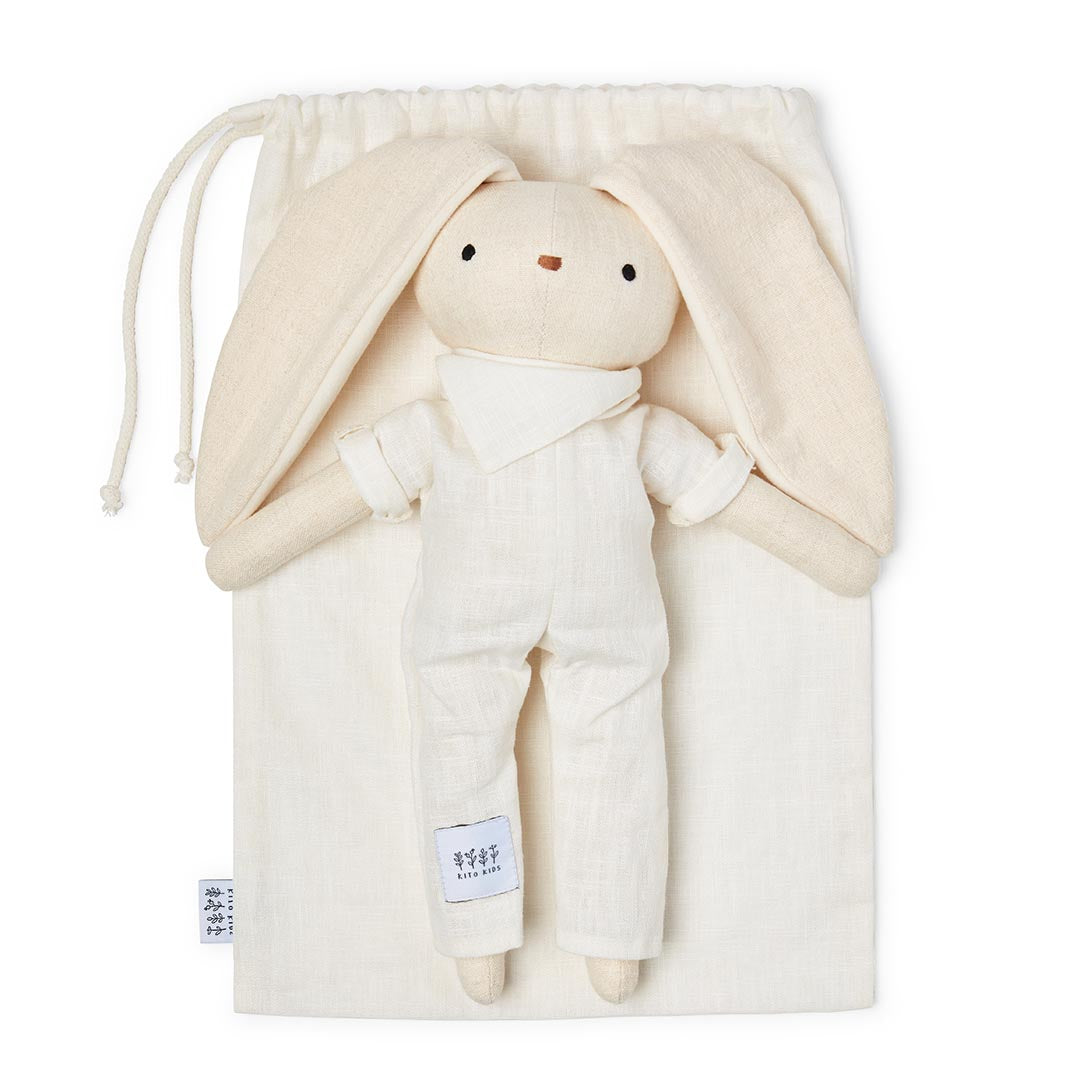 Poupée lapin de naissance de couleur écru avec une étiquette blanche Kito Kids cousue sur la jambe, sur fond blanc.