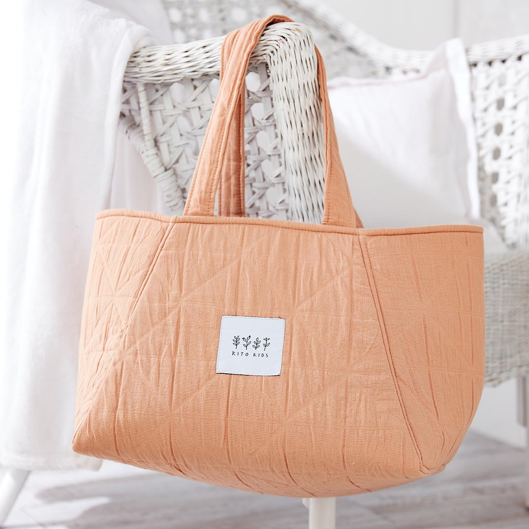 Sac de maternité matelassé en mousseline de coton couleur terracotta pêche de la marque Kito Kids.