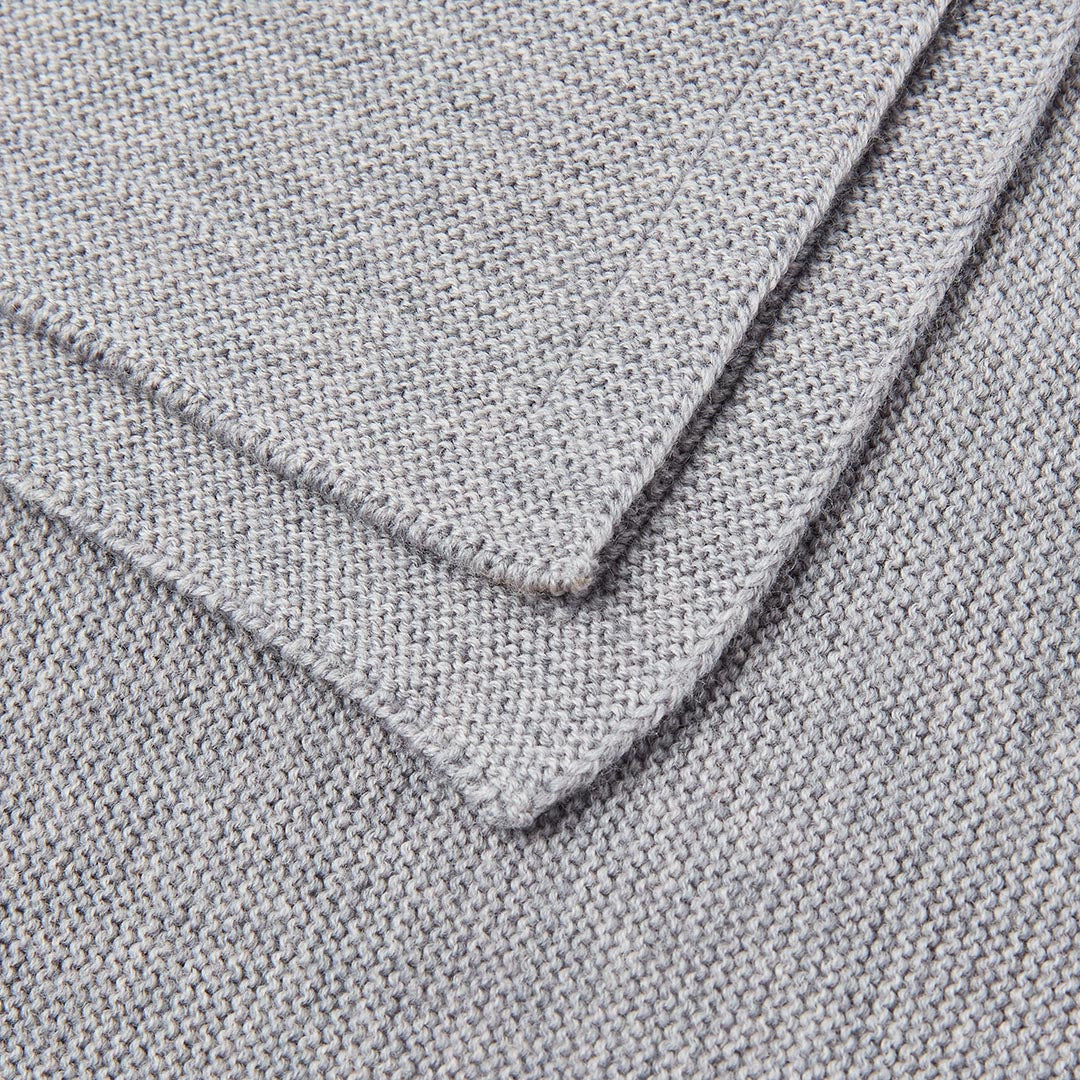 Zoom sur les détails d'un tissage en tricot de coton de qualité supérieure, révélant une maille souple, douce et chaude pour la peau sensible des nouveau-nés.