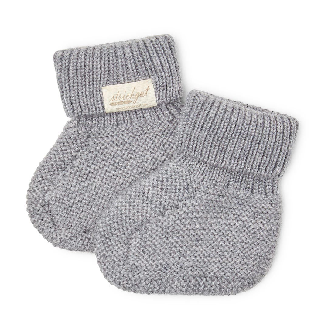 Paire de chaussons de naissance pour bébé en maille tricotée grise, présentés à plat sur fond blanc.