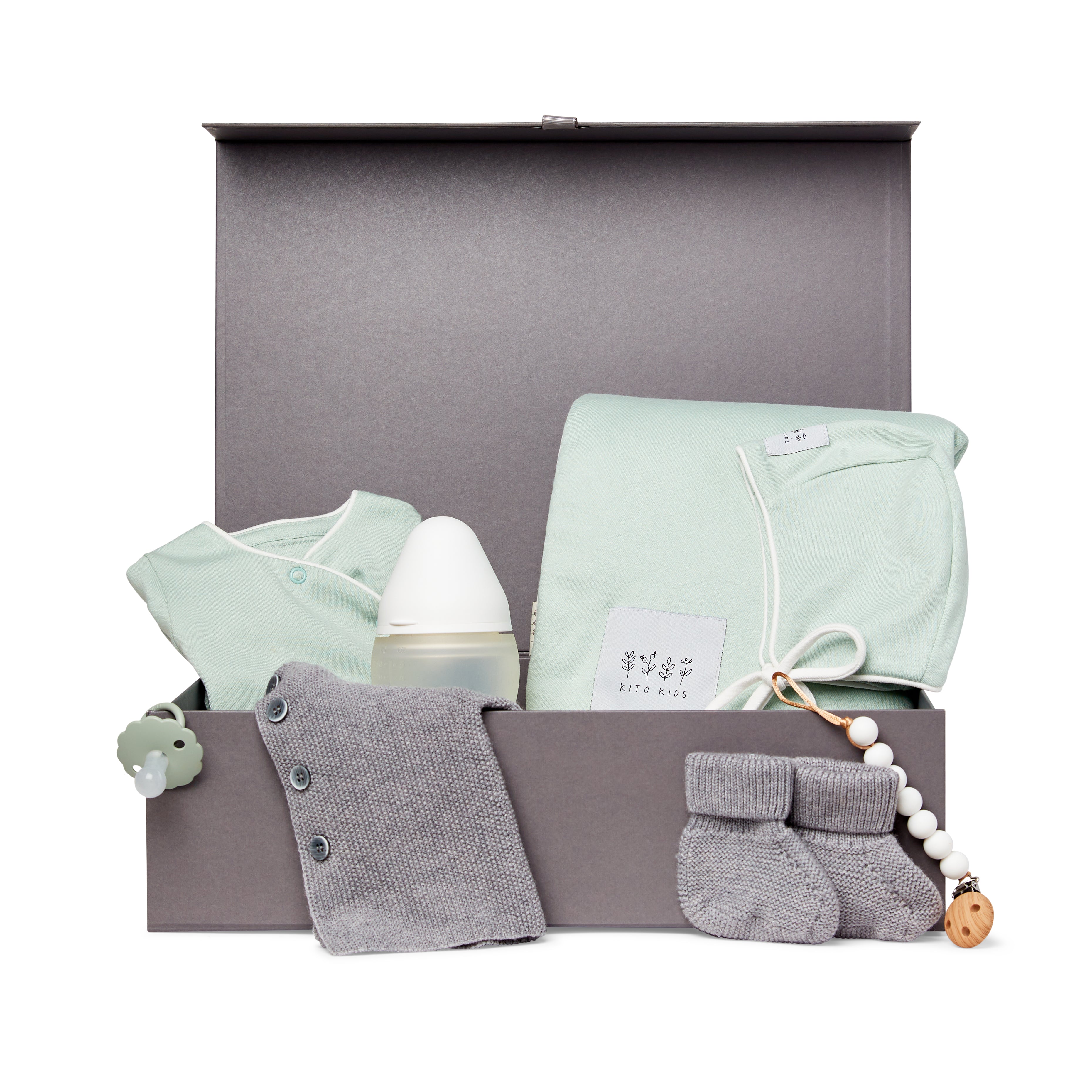 Coffret naissance Kito Kids avec couverture vert d’eau, cardigan en laine mérinos gris, brassière vert d’eau, chaussons, biberon, tétine et attache-tétine.