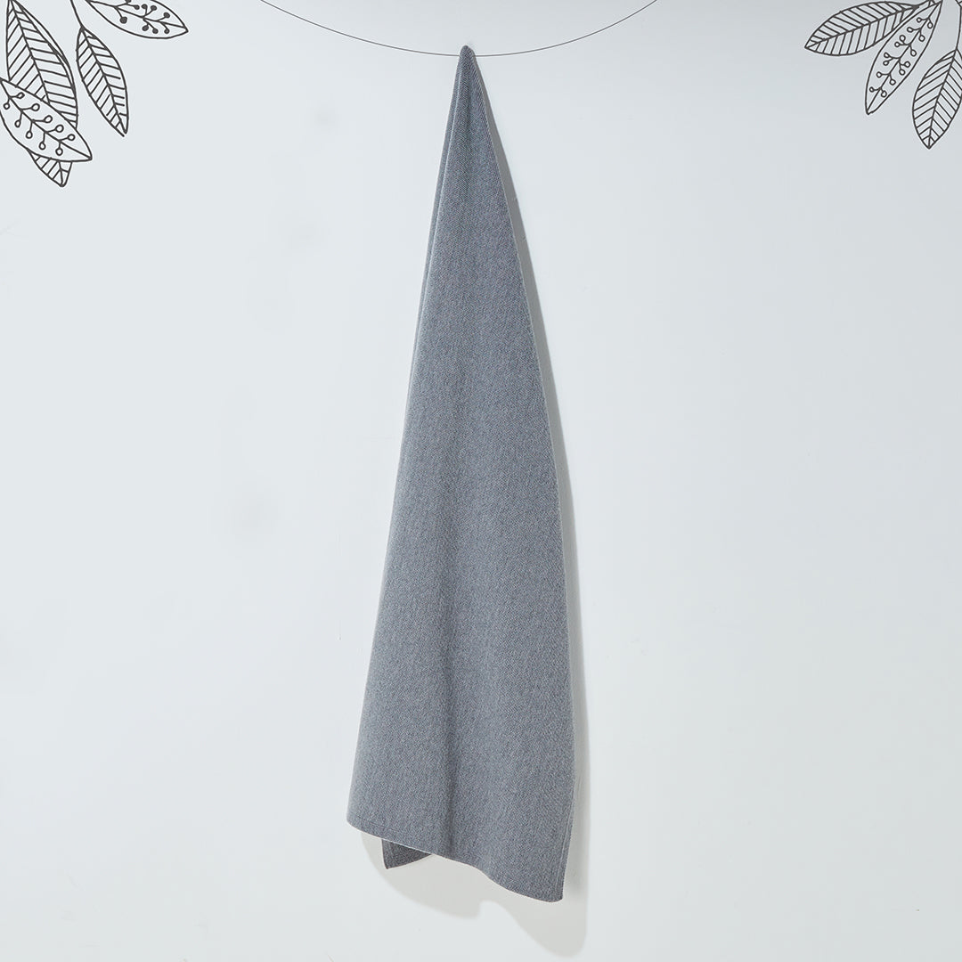 Couverture pour bébé en maille tricotée grise suspendue, idéale comme plaid de naissance doux et respirant pour le berceau ou la poussette.