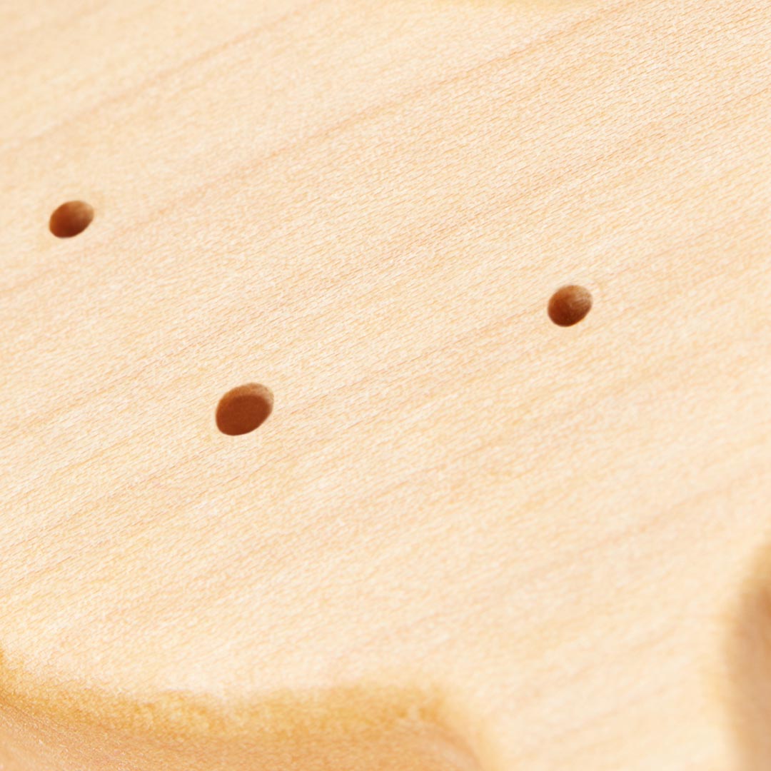 Gros plan sur la texture lisse, les détails des fibres et les finitions soignées d'un anneau de dentition en bois de hêtre naturel pour bébé.