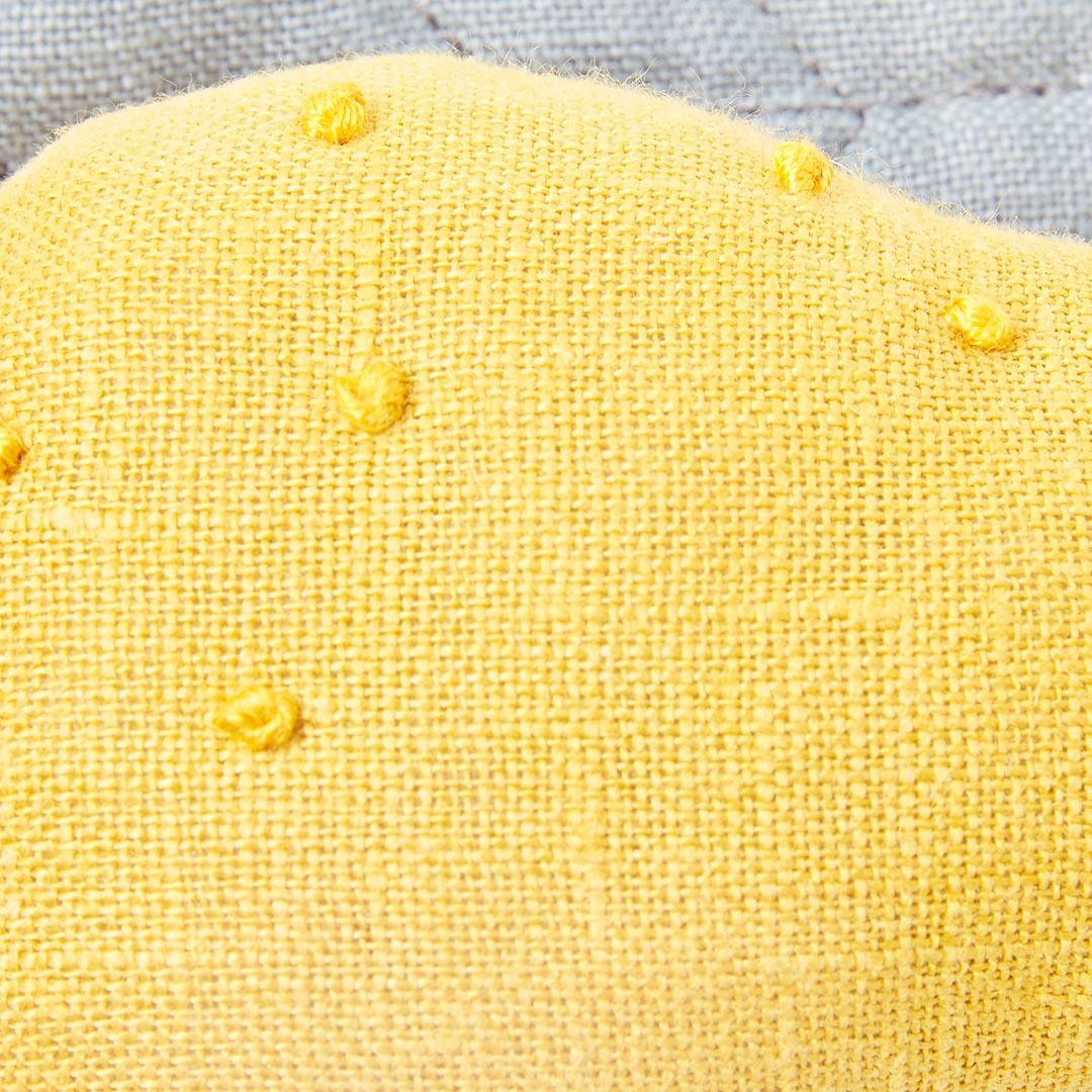 Gros plan sur la texture douce et respirante en coton du hochet d'éveil pour nourrisson.