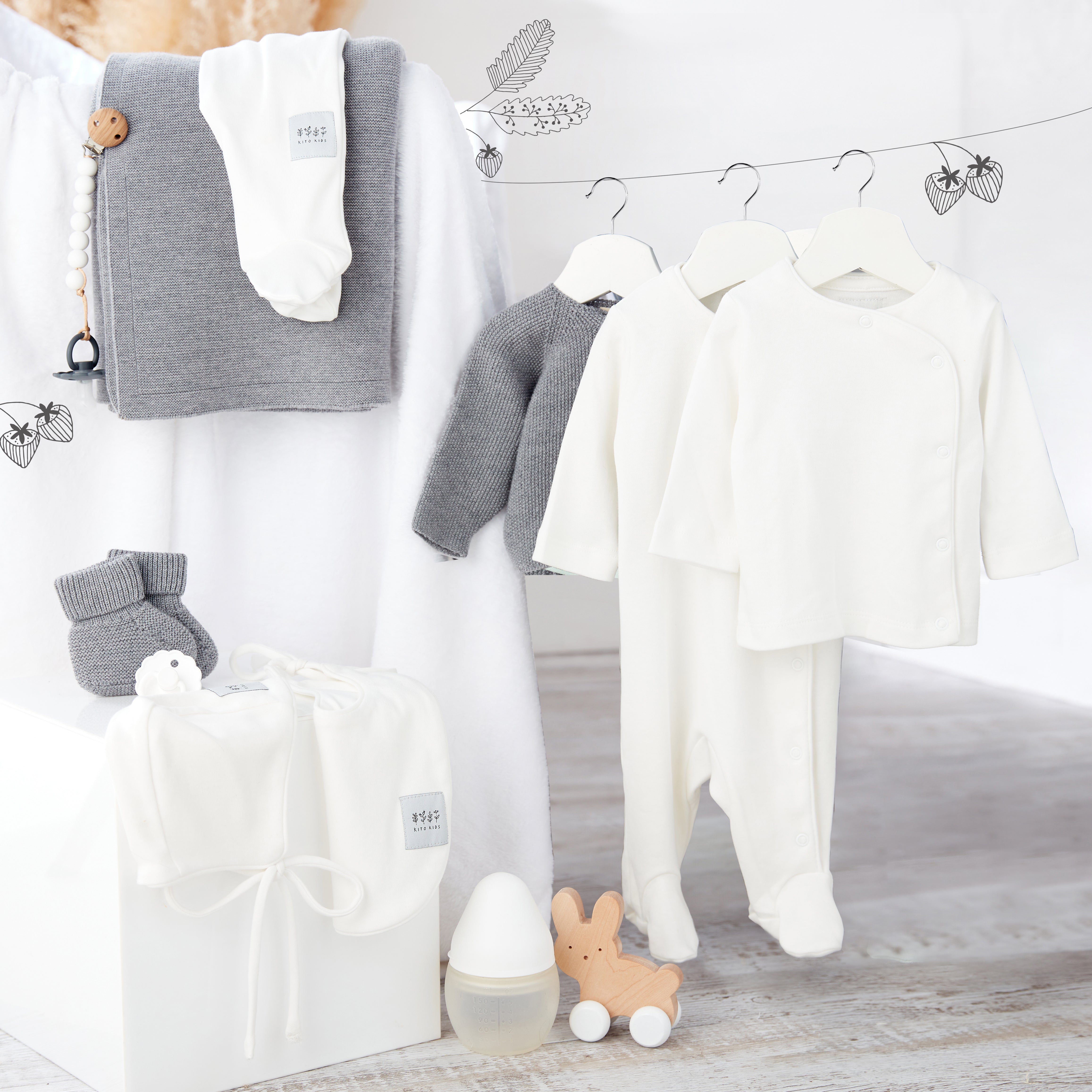 Ensemble de naissance pour bébé en blanc et laine mérinos avec pyjama, gilet, bonnet, bavoir, chaussons et couverture Kito Kids.