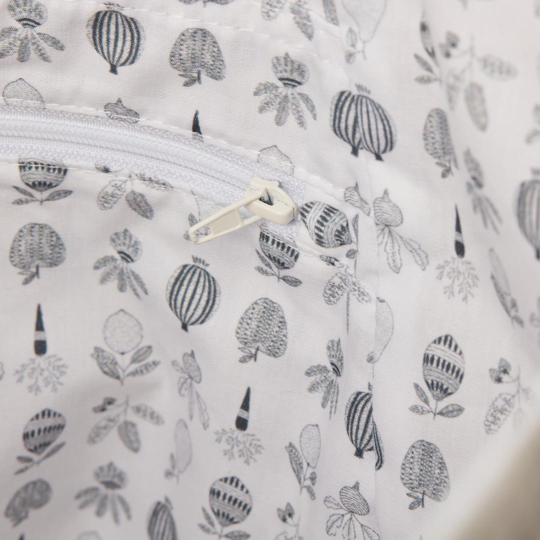 Gros plan sur la poche intérieure zippée et la doublure blanche imprimée de motifs botaniques gris d'un sac de maternité.