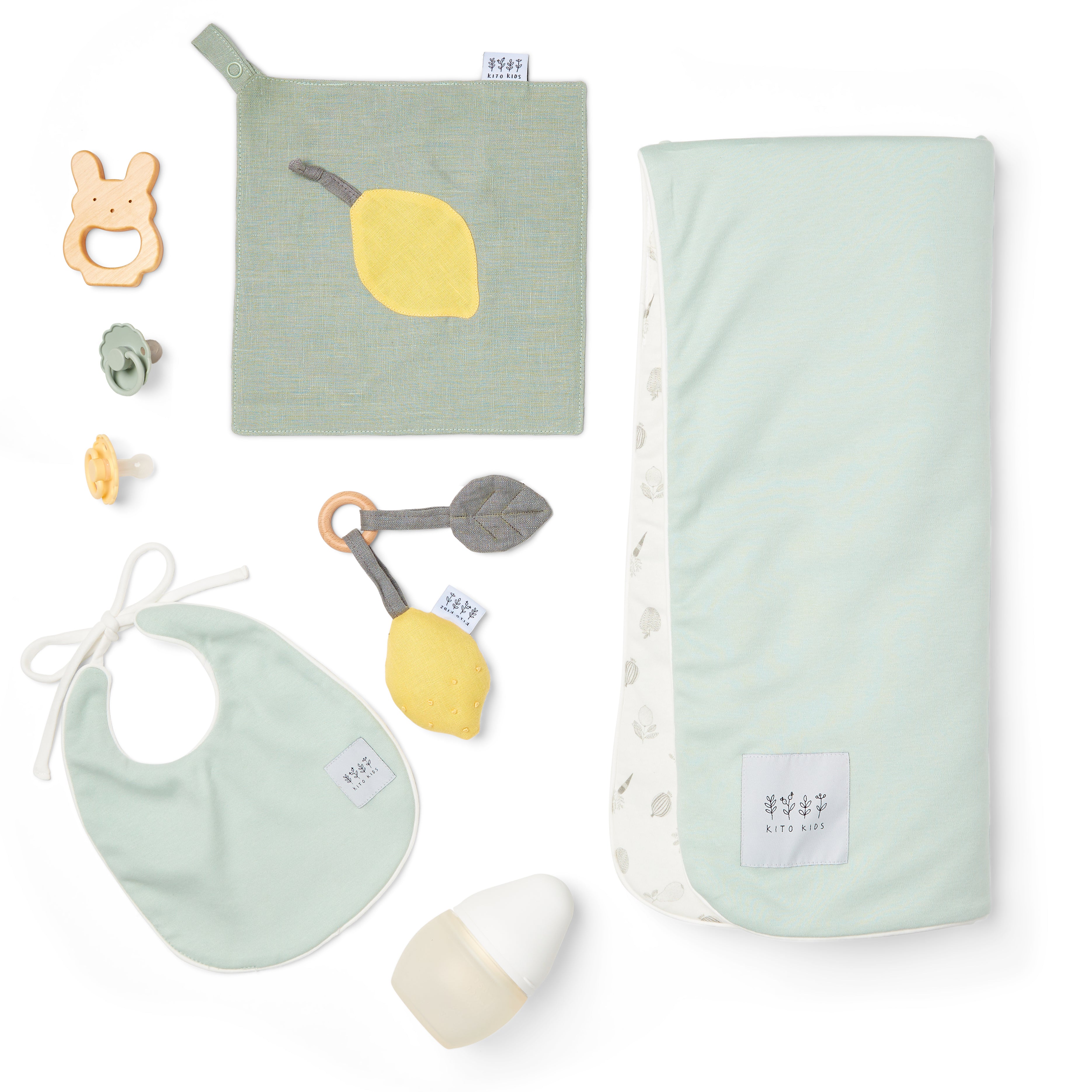 Kit de naissance complet pour bébé Kito Kids contenant un lange écoresponsable, un bavoir, un doudou plat citron, un hochet de dentition en bois, un biberon et des tétines.