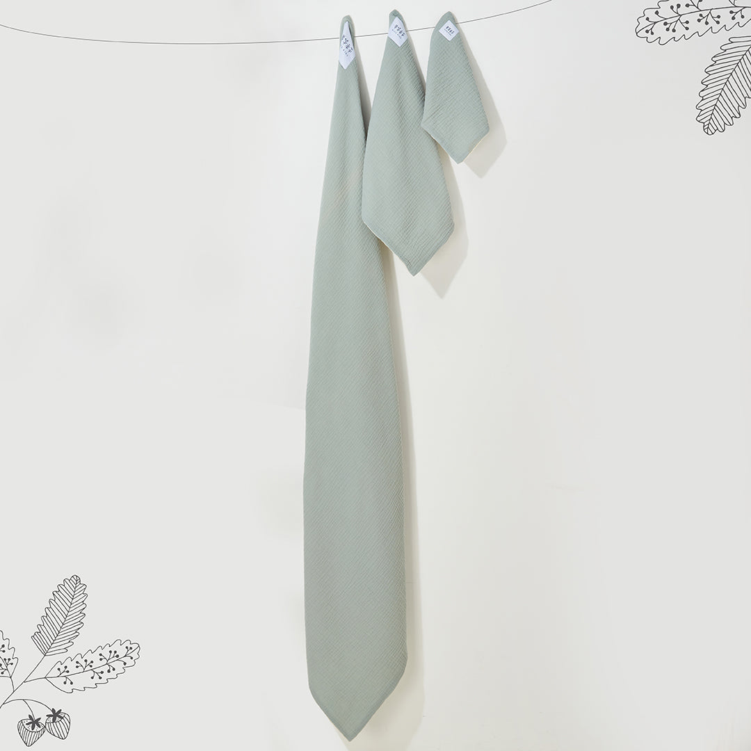 Pack de trois langes suspendus en gaze de coton vert sauge de tailles différentes avec leurs étiquettes Kito Kids.
