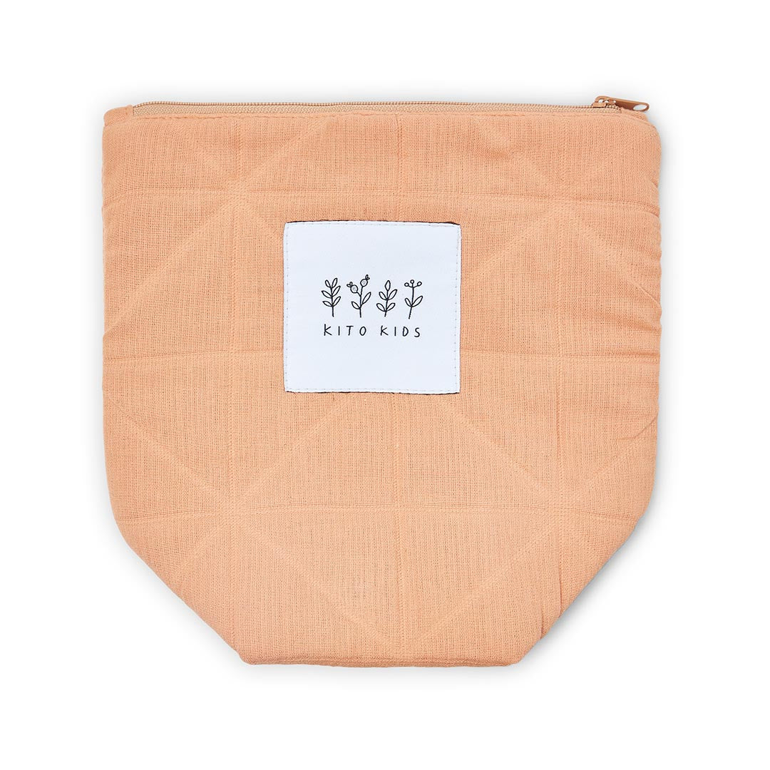 Pochettes de toilette en coton matelassé terracotta de Kito Kids, shampoing et crèmes pour la toilette de bébé.