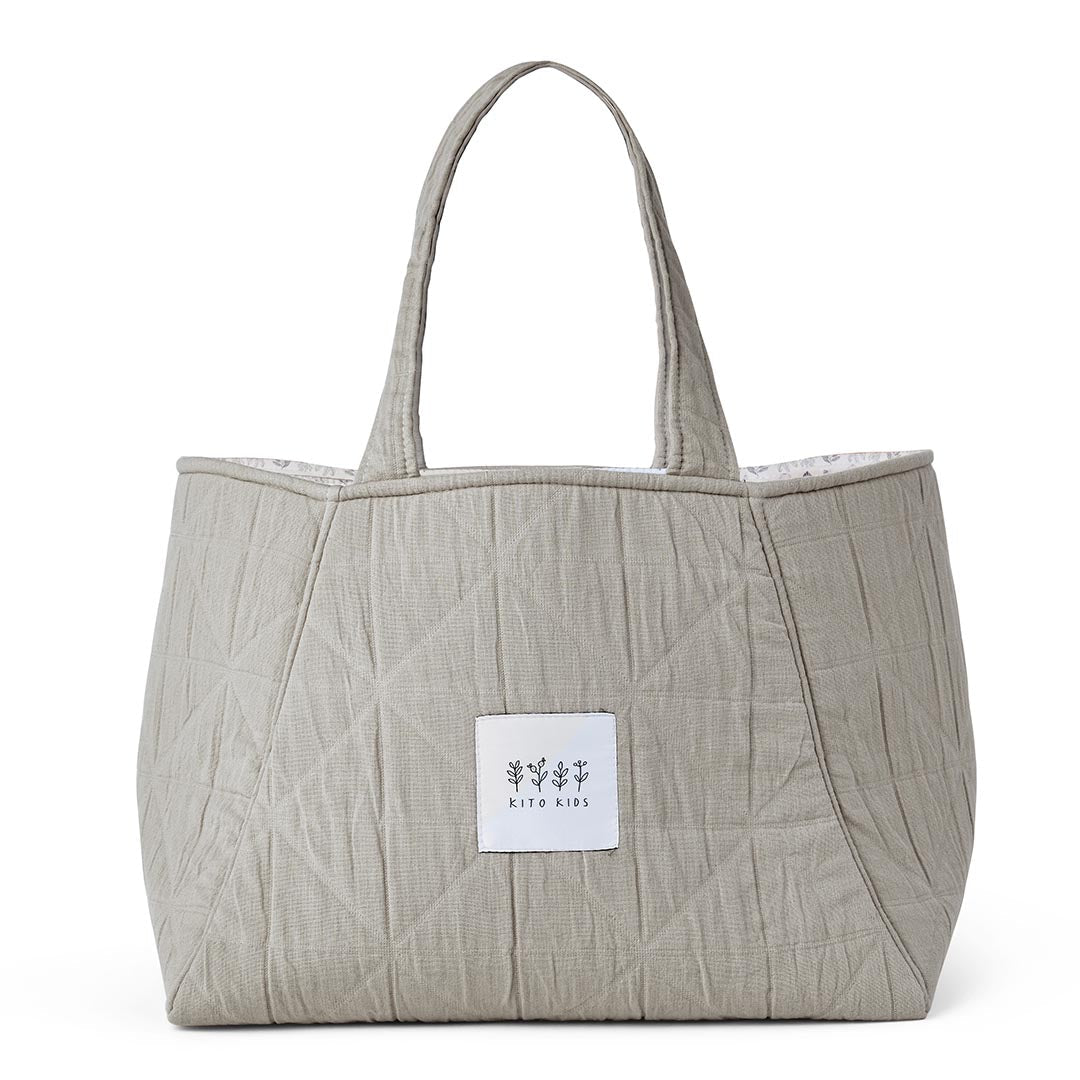 Sac à langer matelassé de couleur beige avec de grandes anses et le logo Kito Kids.