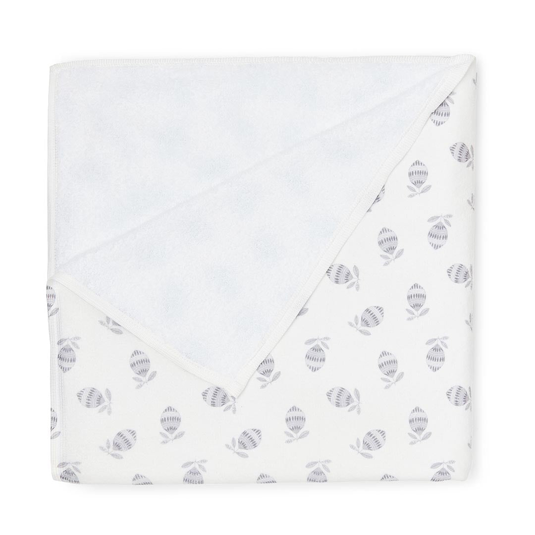 Serviette de toilette blanche pour bébé ornée de petits motifs végétaux de couleur gris clair.