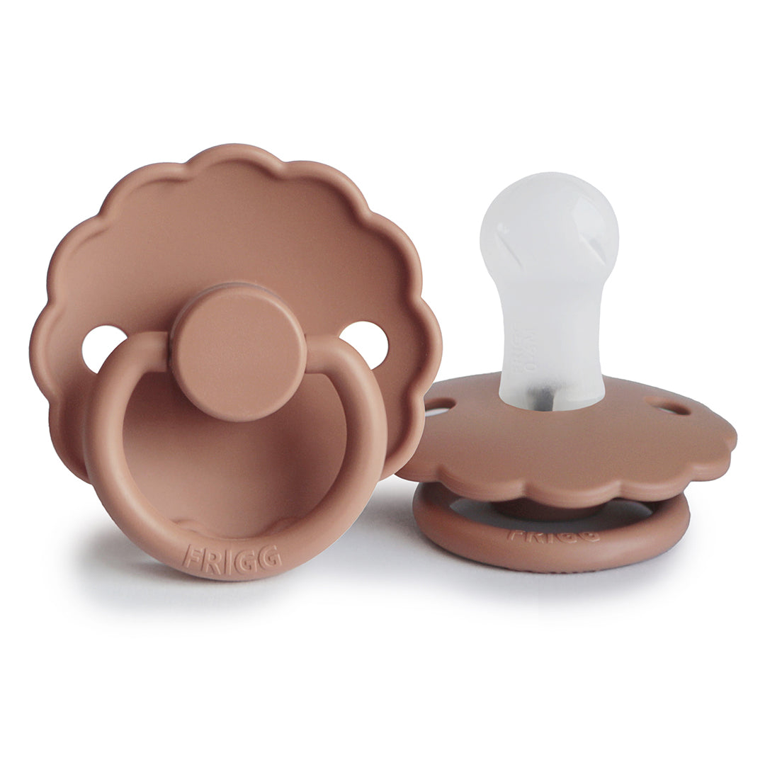 Tétine de naissance Frigg Daisy rose poudré foncé dotée d'une collerette ergonomique imitant les pétales d'une fleur.